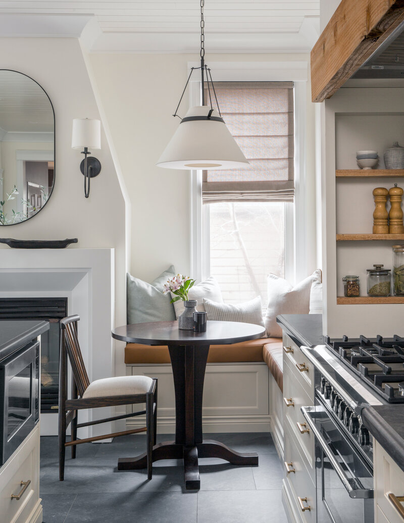 cozy breakfast nook with camel leather banquette seating next to a fireplace in a kitchen